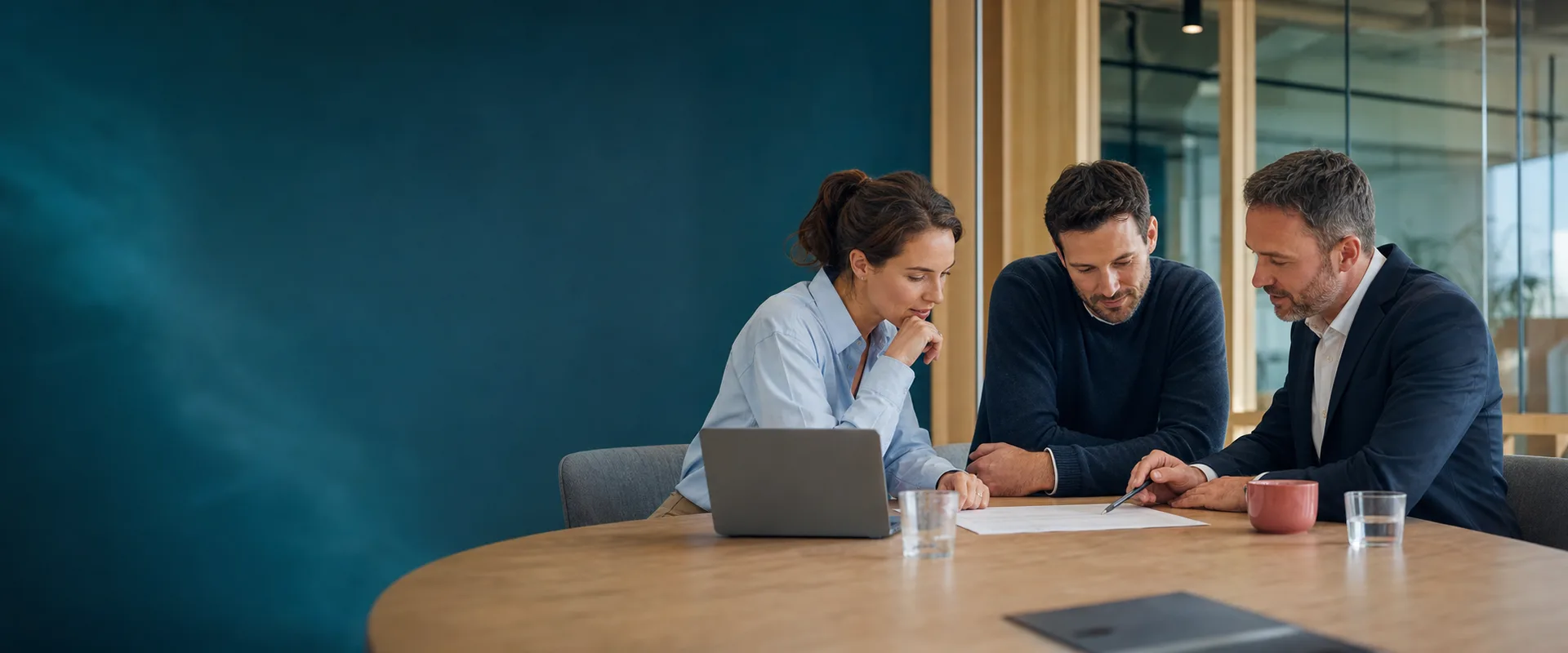 Three professionals discussing a business document